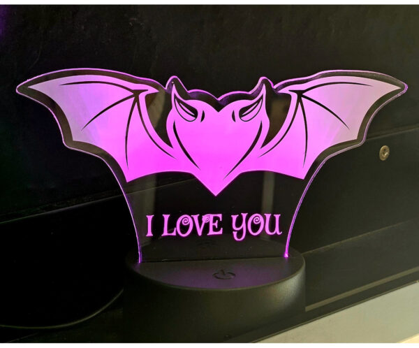 lámpara de acrílico con el diseño de un murciélago con forma de corazón.