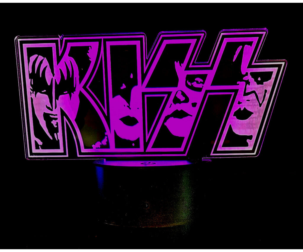 Esta lámpara decorativa resalta el nombre "Kiss" y los rostros de los integrantes con las luces vibrantes de led