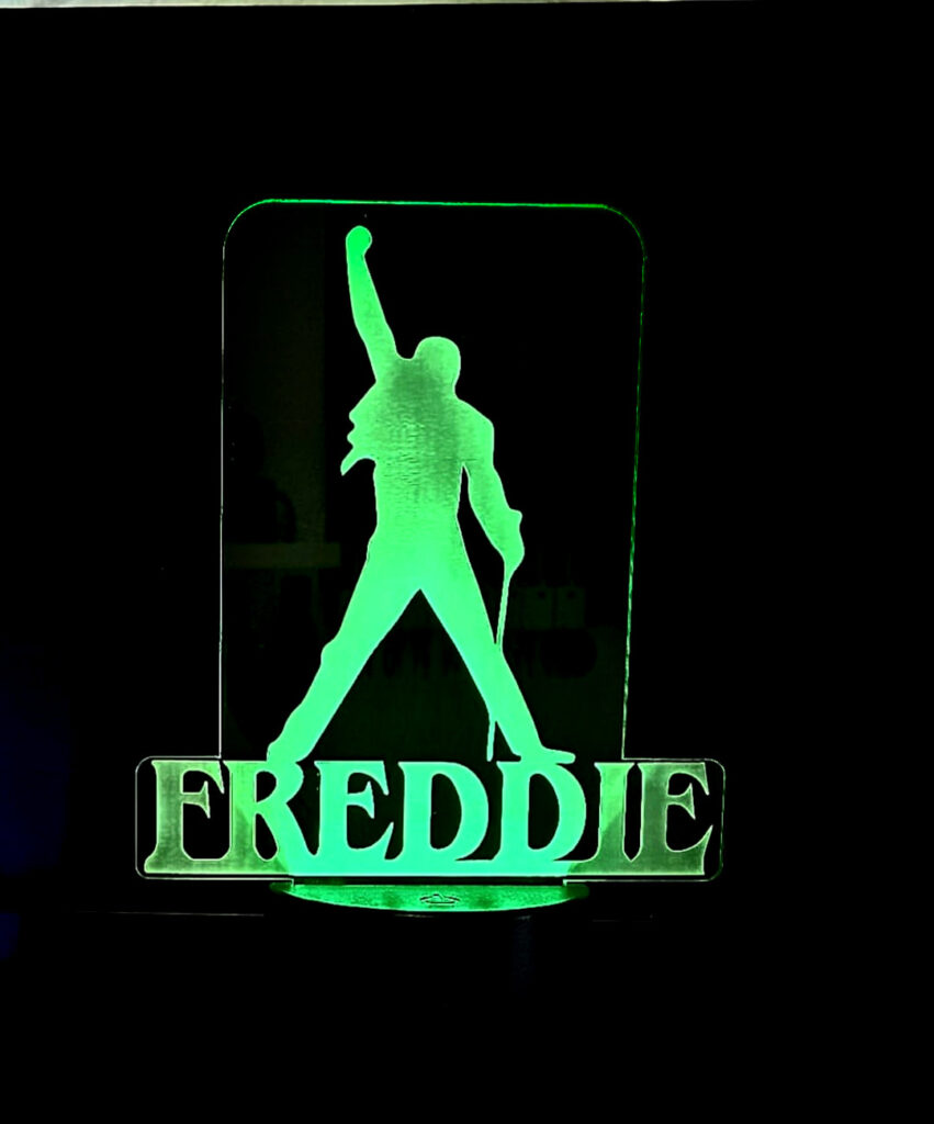 Esta lámpara presenta la silueta de Freddie Mercury en luces LED, creando un efecto visual elegante y llamativo.